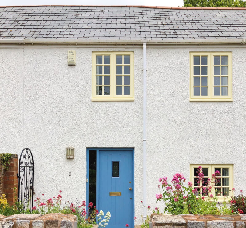 White House with blue door and yellow windows in Devon