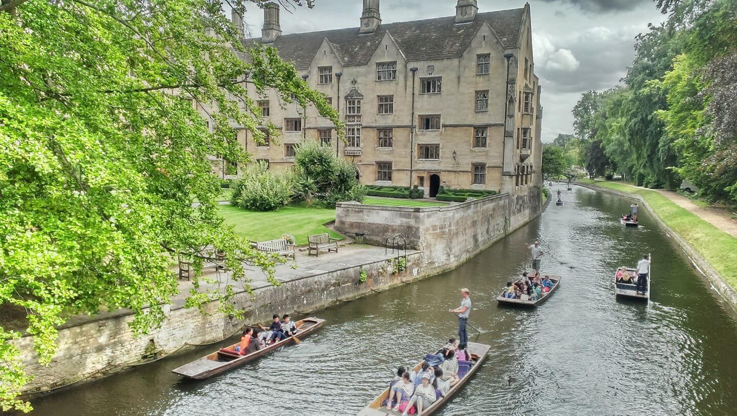 Punting in Cambridge with old buildings and green trees making it one of the best weekend trips in the UK