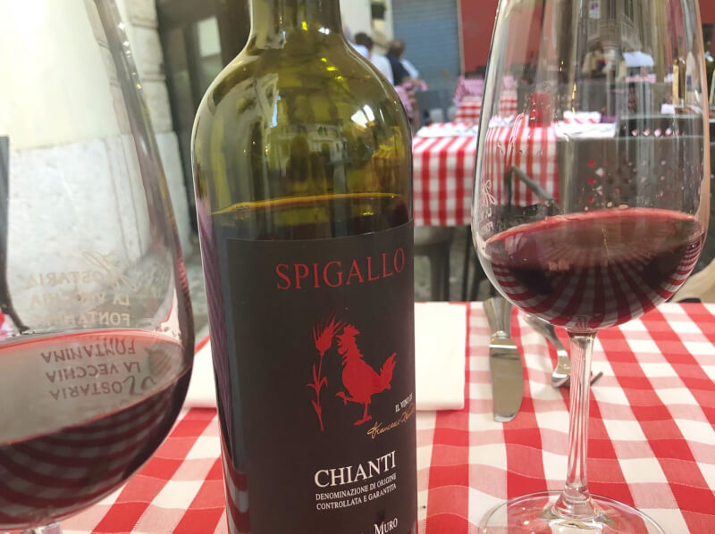 image of red wine bottle and checked table cloth at Hostaria Vecchia Fontanina