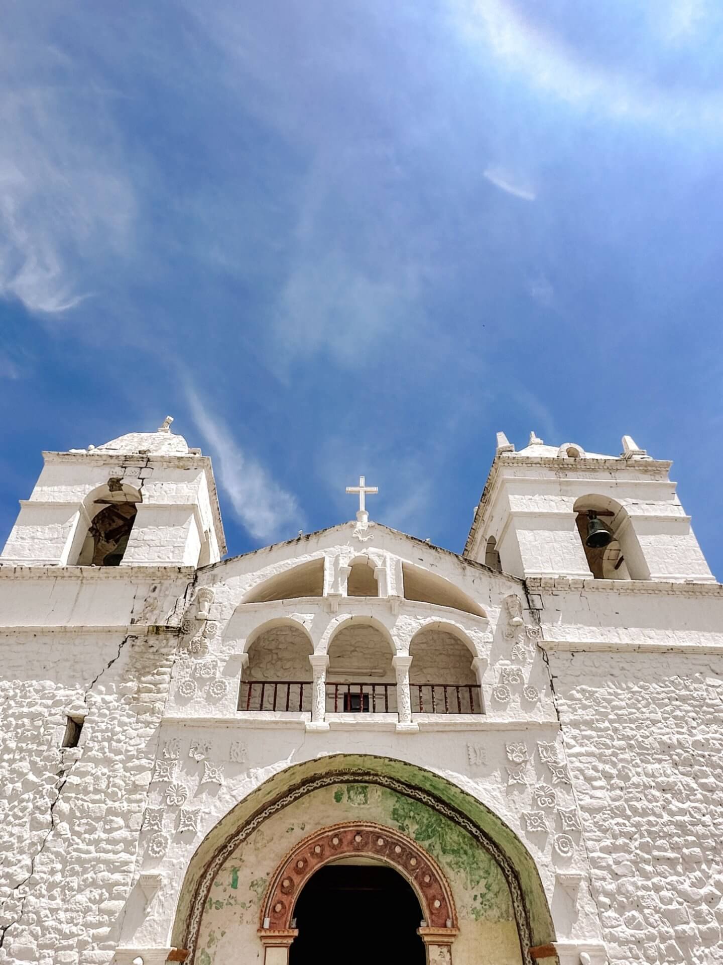 Image looking up at a white church against a blue sky in Maca in the Colca Canyon in Peru