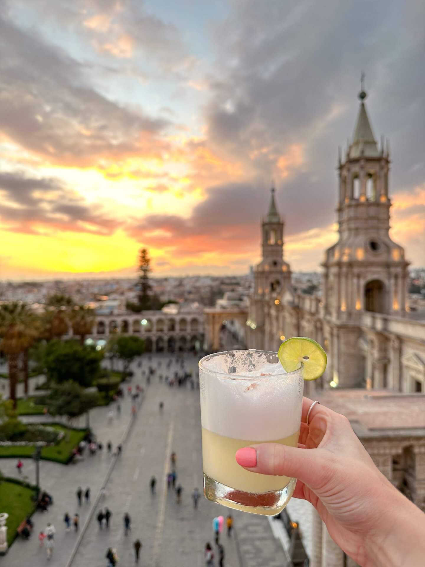 Image of orange and yellow sunset over basilica catherdral of Arequipa with a pisco sour 