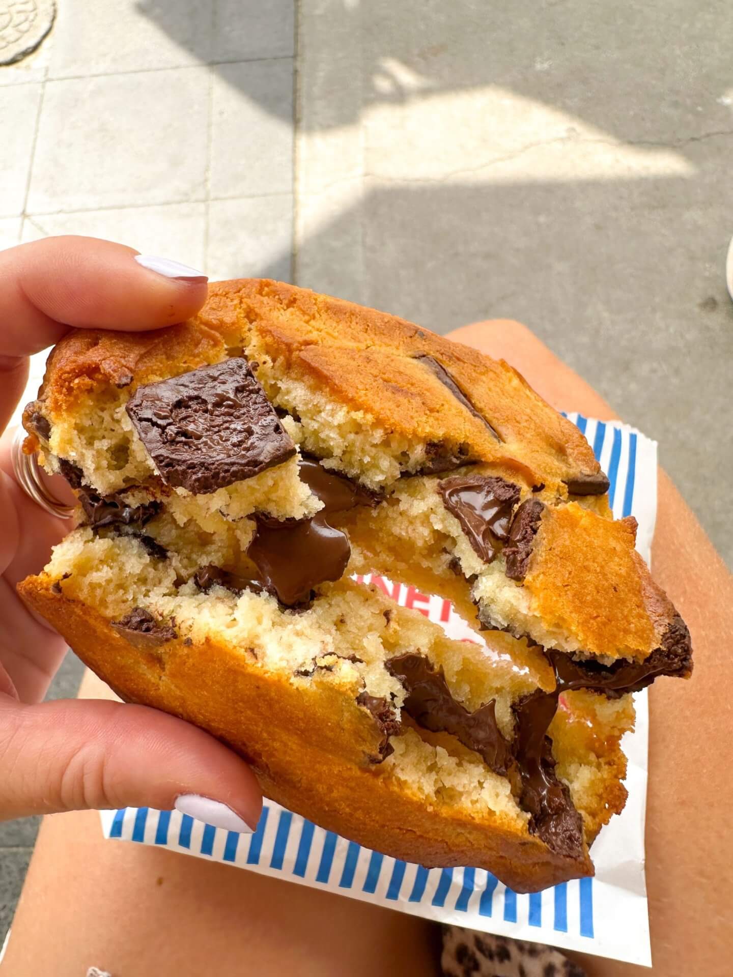 image of a bennett st dairy cookie snapped in half, showing the gooey, melted chocolate in the middle.