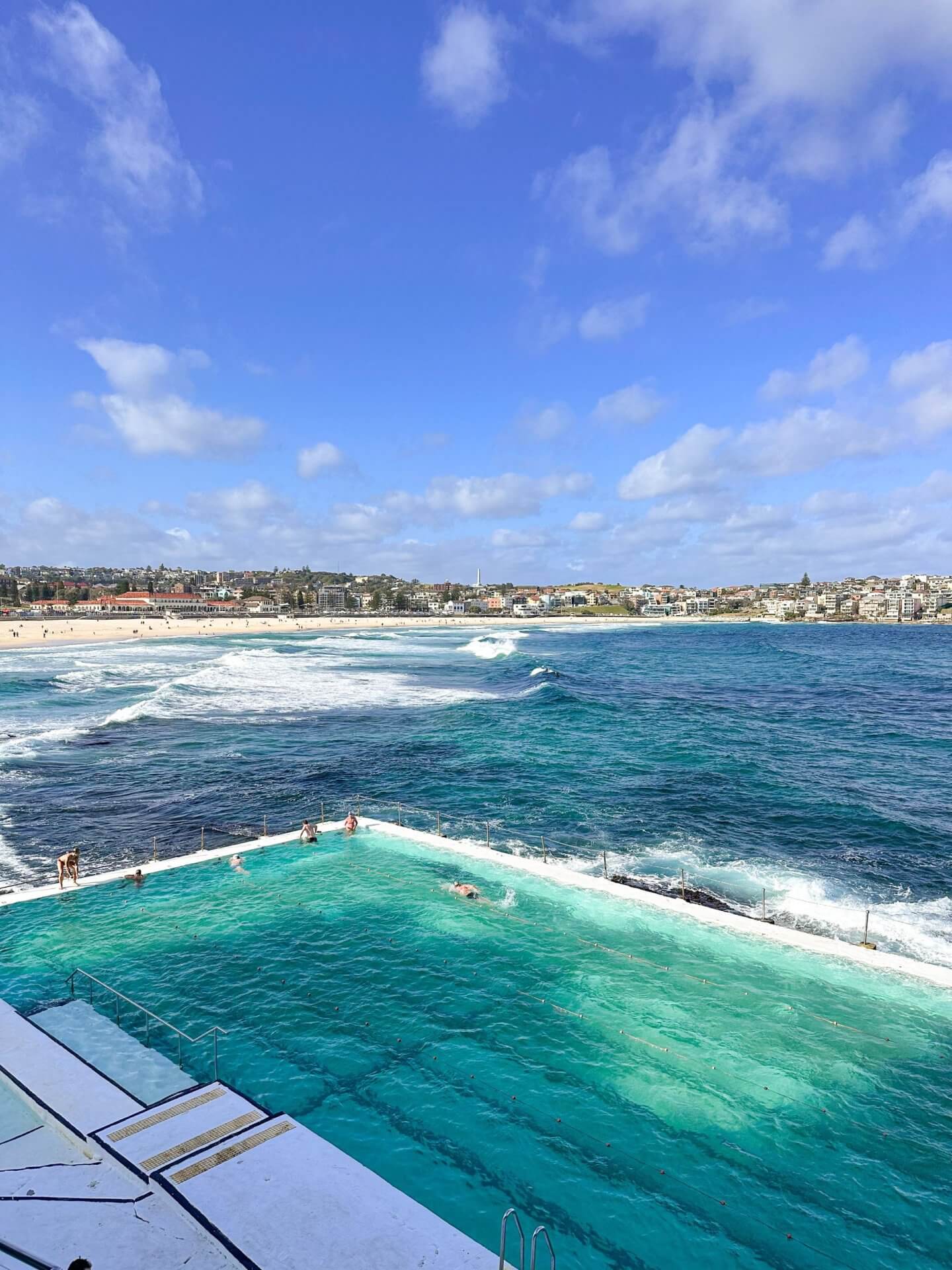 image of swimmers at Bondi Icebergs with waves crashing over the edge