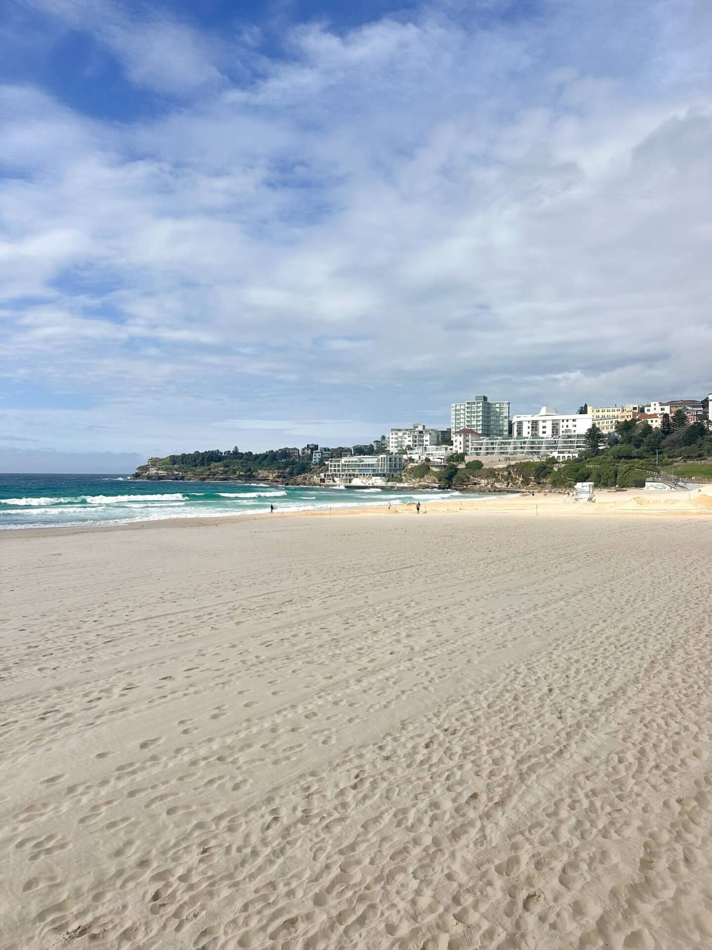 image of the white sands stretching all the way to the blue sea of Bondi Beach