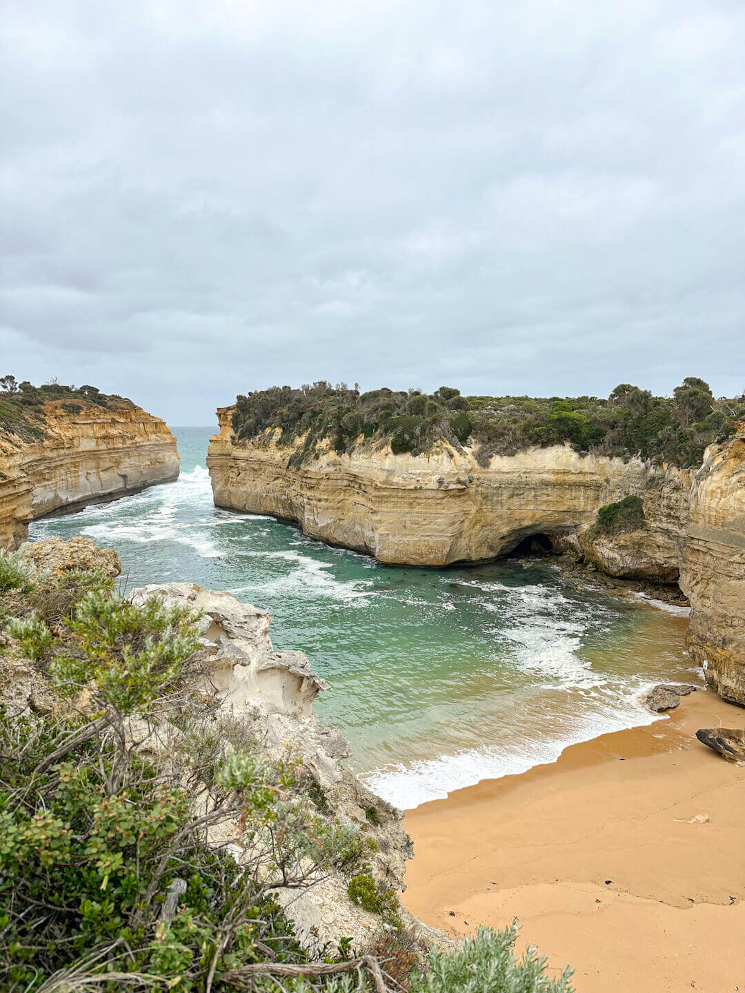 loch ard gorge as seen from above, with the waves lapping at the sandy cove beach