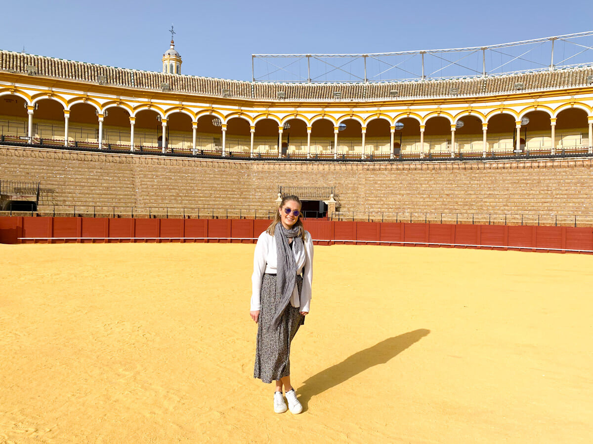 Charlie is standing alone in the middle of the bull ring in Seville while solo travelling