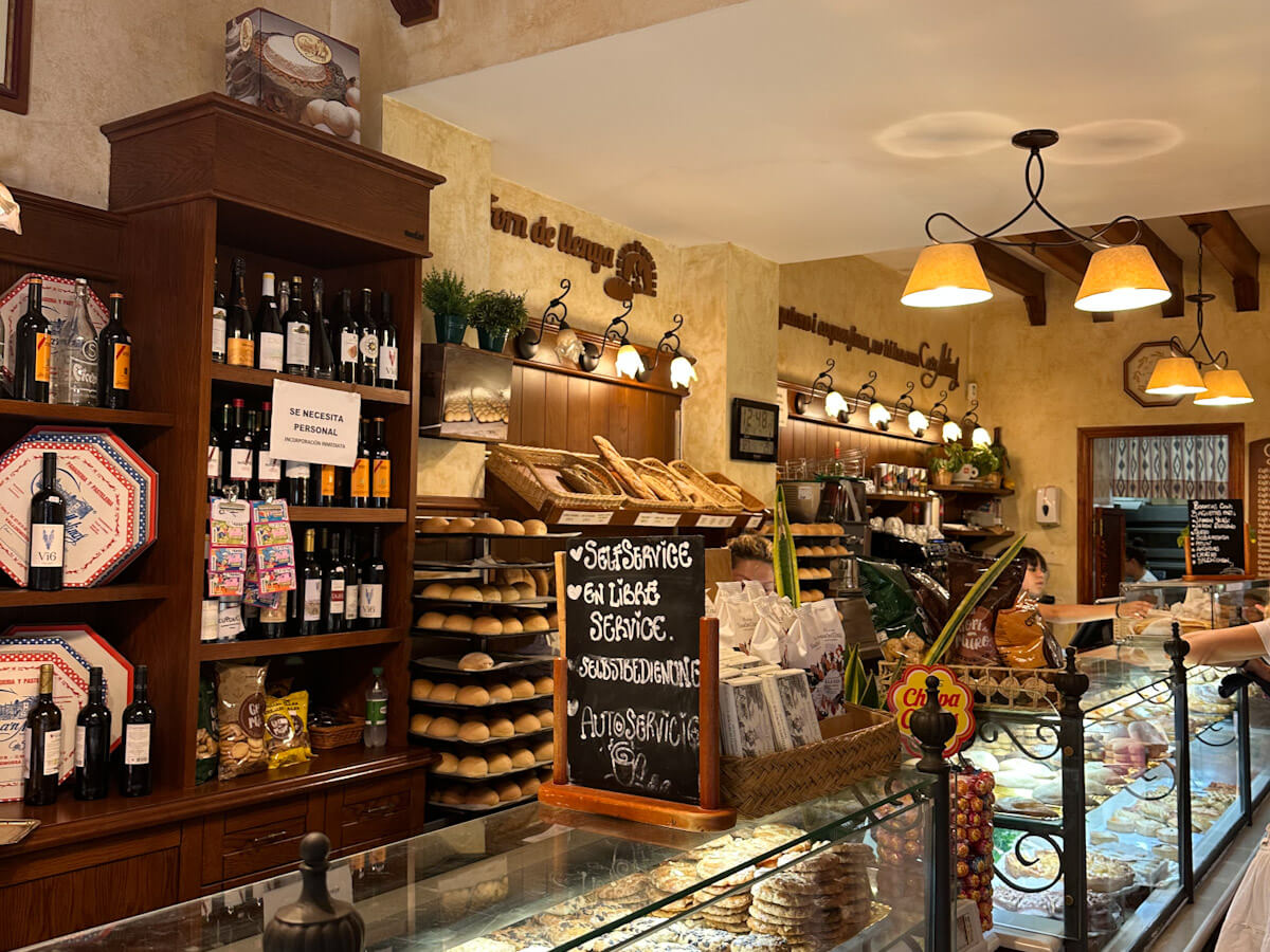 Interior view of the historic Can Molinas bakery in Valldemossa, featuring pastries, bread, and local products.