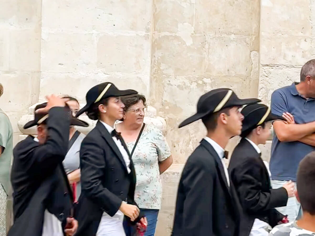 Caixers riders in traditional black jackets, white shirts and tricorn hats gathering outside the church in Es Castell ahead of the Sant Jaume Menorca fiesta procession