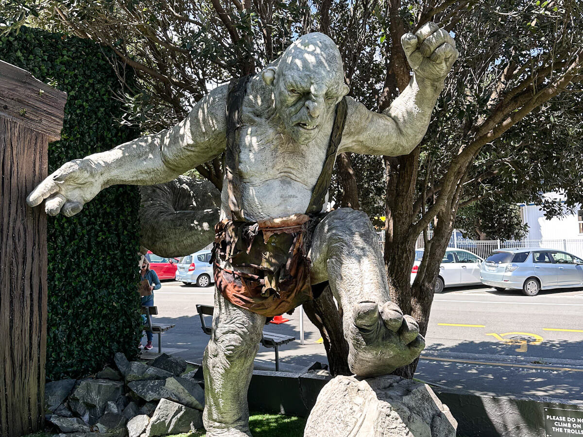A massive, hyper-realistic sculpture of a cave troll from The Lord of the Rings standing outside the Wฤtฤ Cave in Miramar. Visiting this film effects studio is a top recommendation for what to do in Wellington for movie fans.