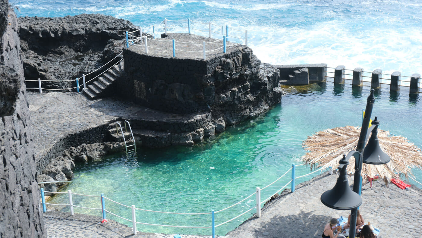 A sunlit view of the crystal-clear turquoise natural swimming pools at Charco Azul, showcasing one of the most relaxing things to do in La Palma.