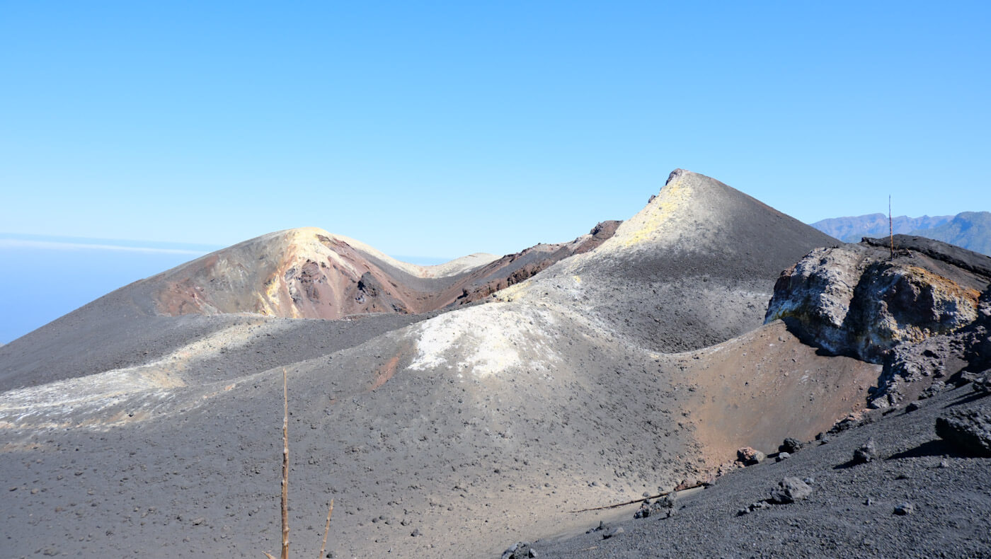 The stark, grey volcanic peaks and ash fields of the newly formed Tajogaite Volcano landscape, representing dramatic hiking adventures for things to do in La Palma.