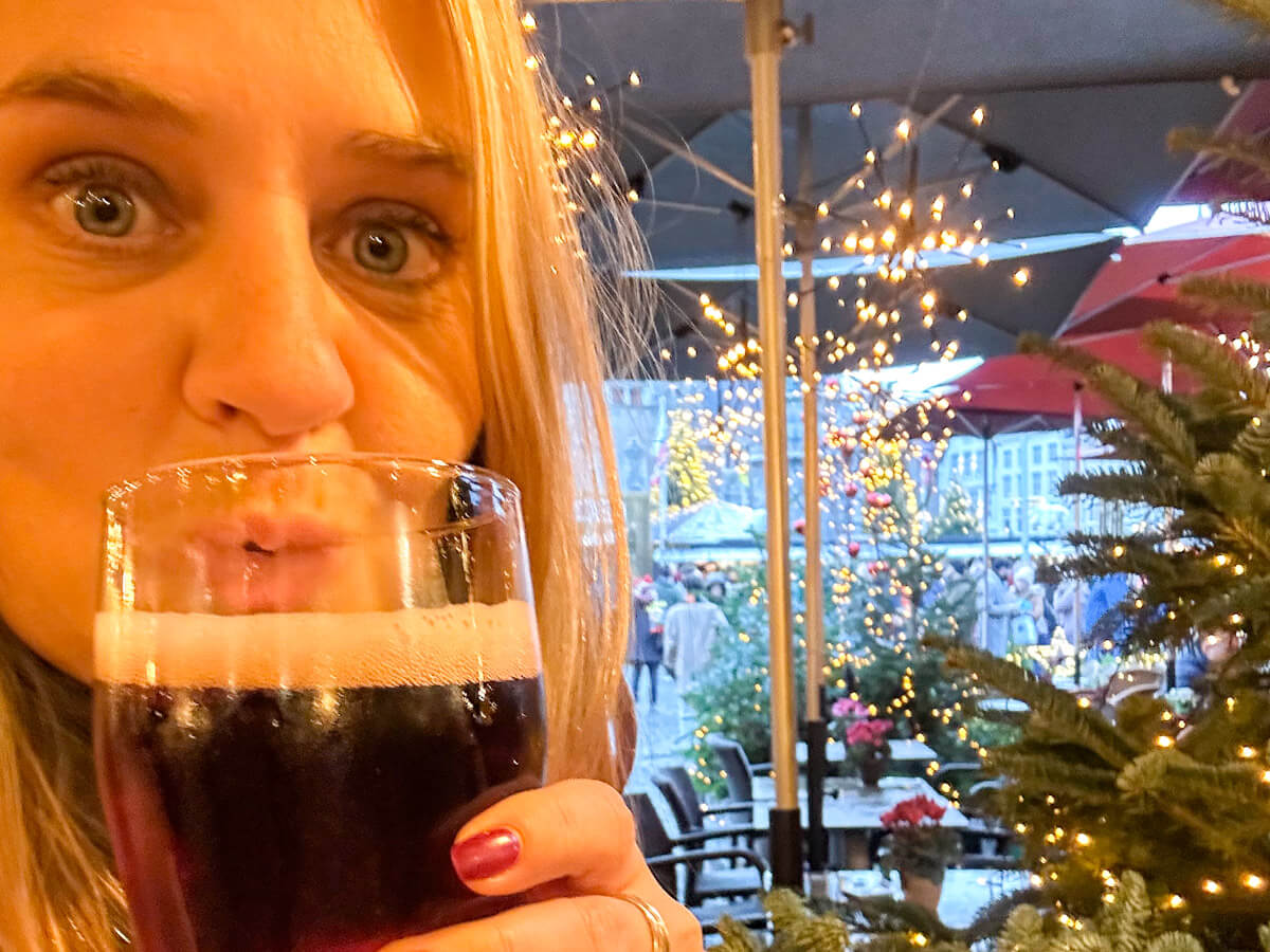 Charlie enjoying a dark Belgian beer at an outdoor terrace during Bruges at Christmas