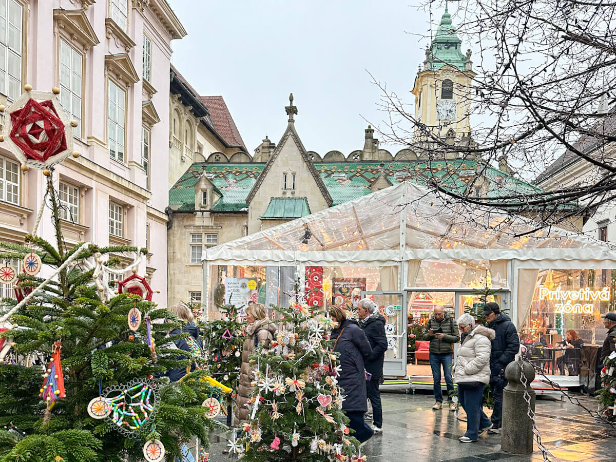 A forest of small Christmas trees decorated with handmade ornaments by local primary school children, on display in front of Primate's Palace during the Bratislava Christmas Market.